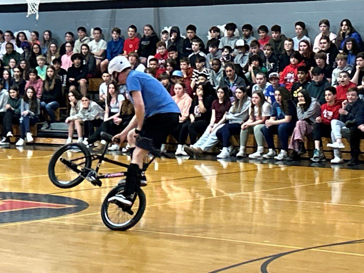 Chris Poulos, world champion bicyclist and stunt rider,  on his bike resenting to HMS Students